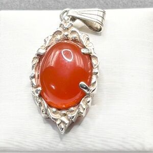 A Sterling Silver Pendent with a reddish, orange color